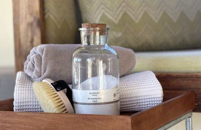 Naturkosmetik im Biohotel Eggensberger: Bio-Basisches Salz von Marias Salzburg mit Massagebürste und Handtüchern für Wellness-Behandlungen im Garten-SPA.