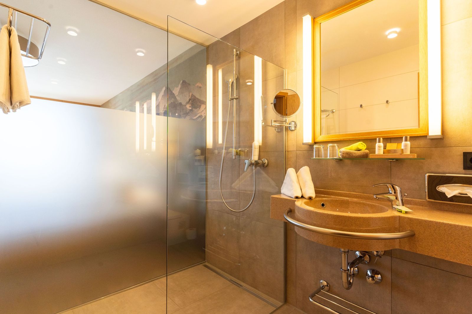 Doppelzimmer Bergblick Badezimmer mit Dusche, Waschbecken, Glastrennwand zum Zimmer