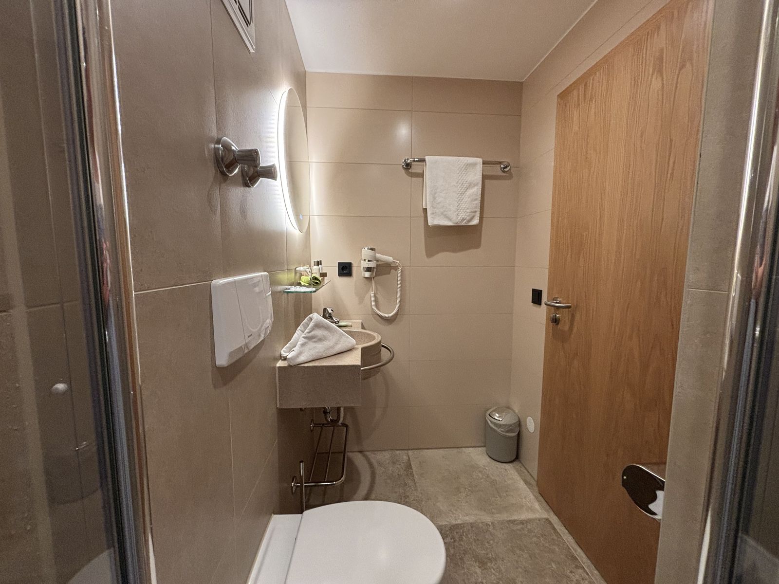 Badezimmer des Einzelzimmers "klein aber fein" im Wellnesshotel mit Spiegel, Waschbecken, Toilette und Dusche