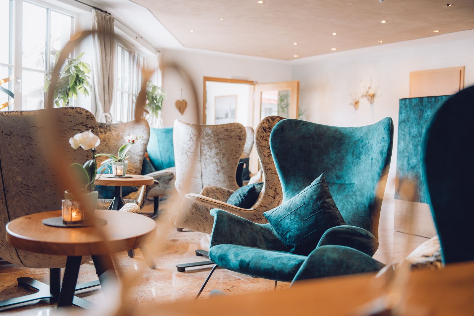 Hotellobby mit petrolfarbenen und grauen Sesseln