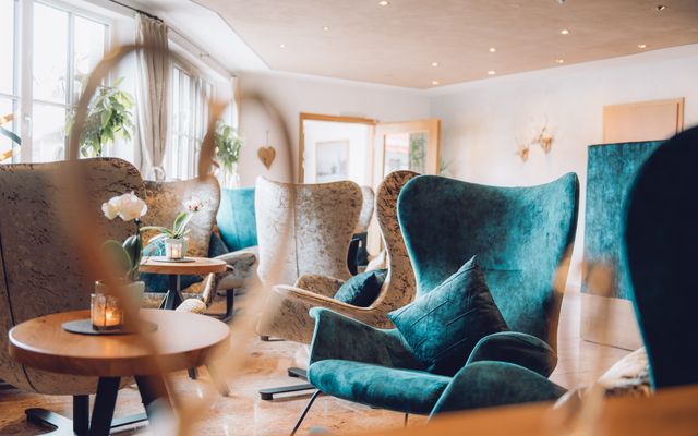 Hotellobby mit petrolfarbenen und grauen Sesseln