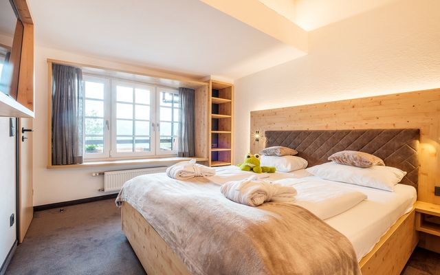 Kinderhotel Allgäuer Berghof – Schlafzimmer der Familiensuite Klapperstorch mit Blick auf die Allgäuer Alpen
