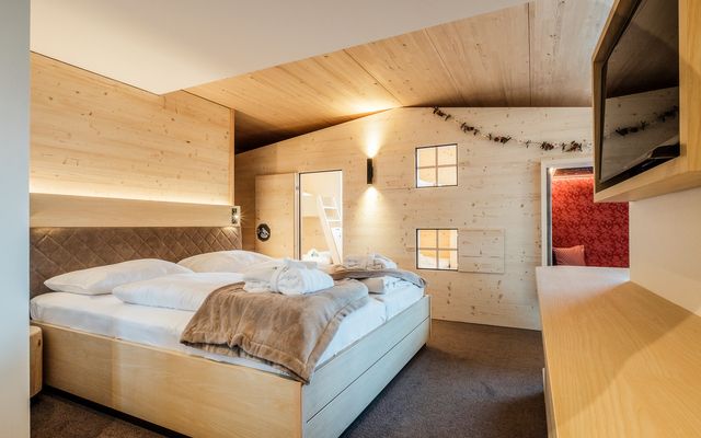 Kinderhotel Allgäuer Berghof – Wohnzimmer der Familiensuite Finkennest mit Blick auf die Allgäuer Alpen