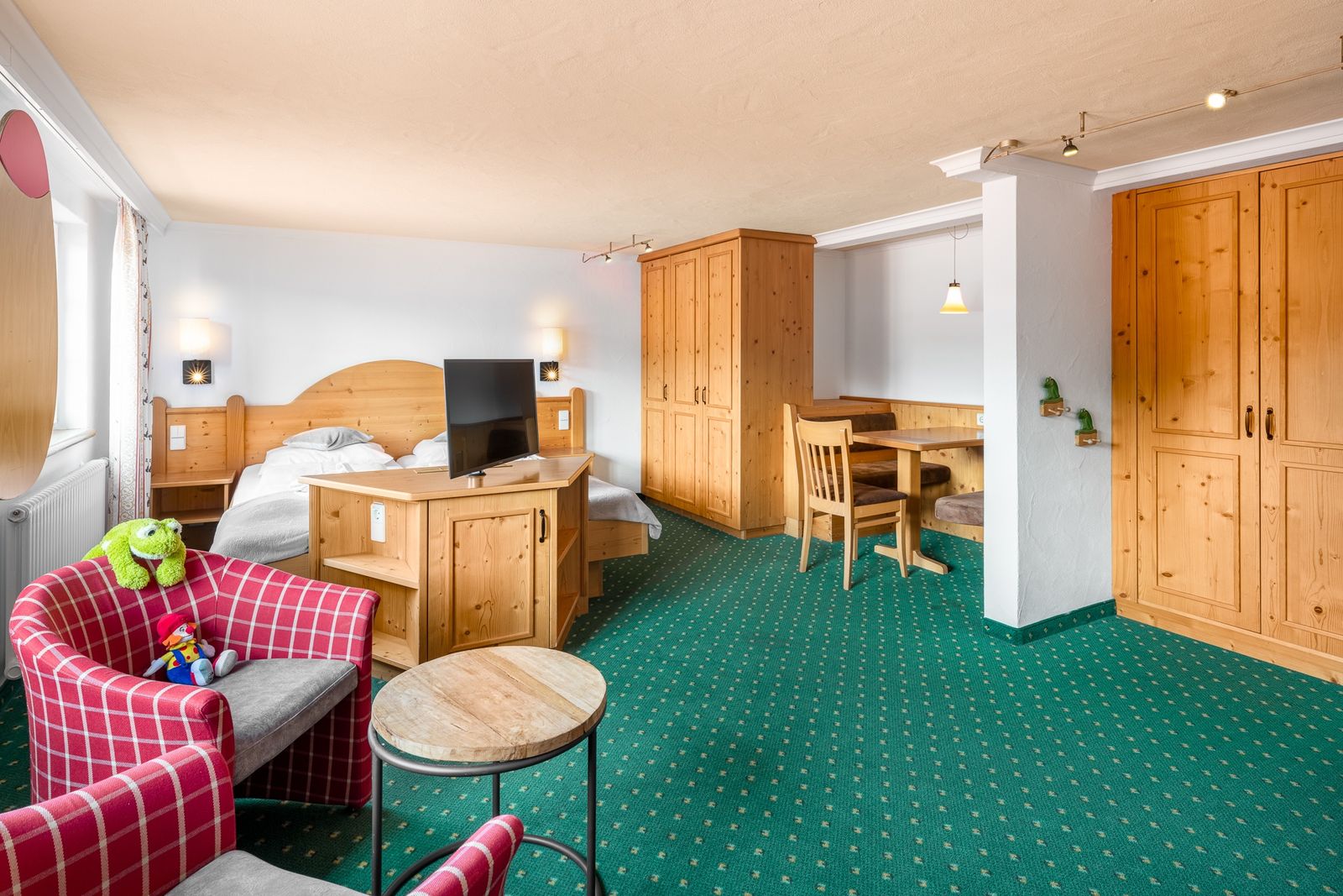 Kinderhotel Allgäuer Berghof – Wohnzimmer Familiensuite Adebar mit Blick auf die Allgäuer Alpen