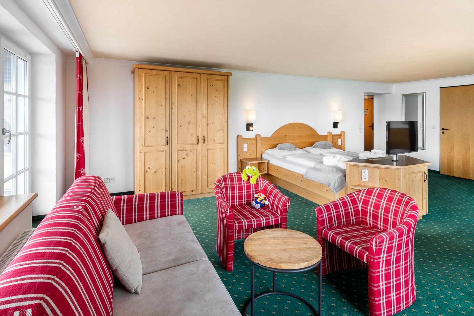 Kinderhotel Allgäuer Berghof – Wohnzimmer Familiensuite Fohlenweide mit Blick auf die Allgäuer Alpen