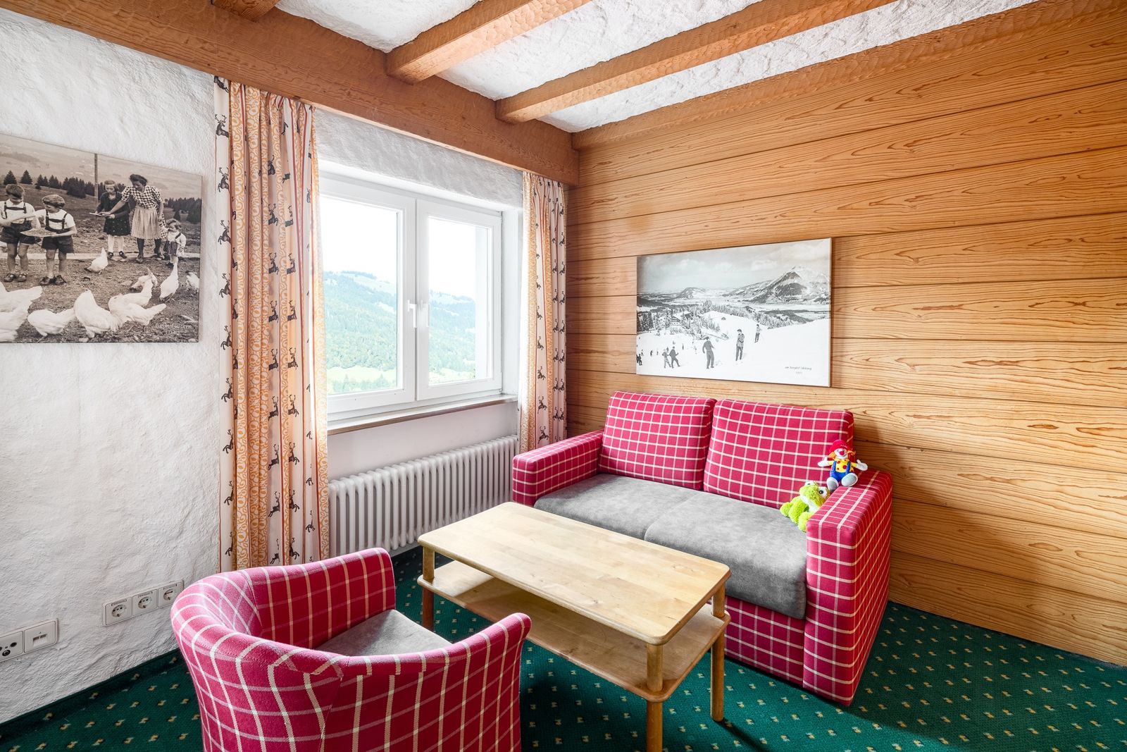 Kinderhotel Allgäuer Berghof – Wohnzimmer Familiensuite Schmetterling mit Blick auf die Allgäuer Alpen