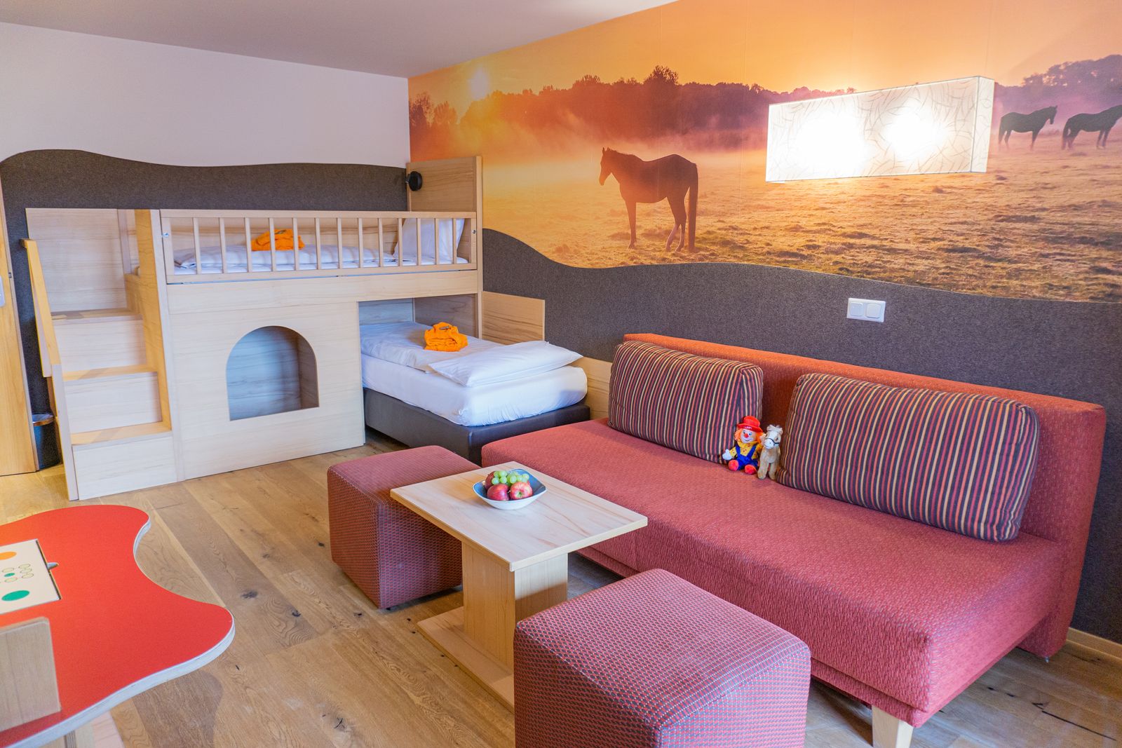 Kinderzimmer mit Hoch- und Querbett, Bällebad unterm Bett, Schlafcouch und Pferdetapete an der Wand