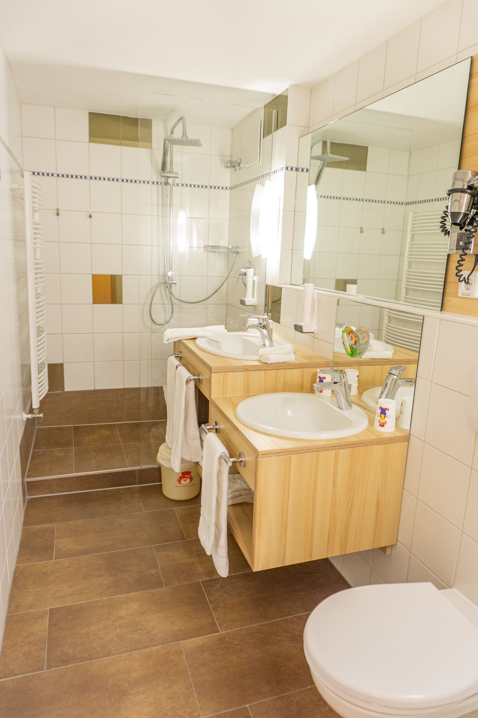 Badezimmer mit Dusche, 2 Waschbecken eines davon niedriger für die Kinder