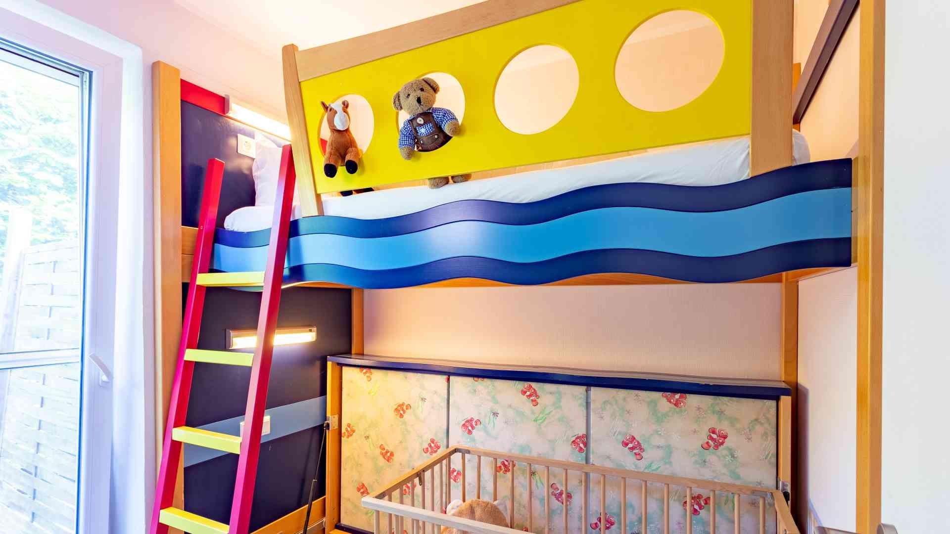 Buntes Hochbett im Stil eines Schiffes auf dem Wasser im Kinderzimmer in der Familien-Suite Typ A