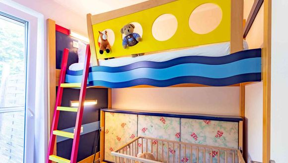 Buntes Hochbett im Stil eines Schiffes auf dem Wasser im Kinderzimmer in der Familien-Suite Typ A