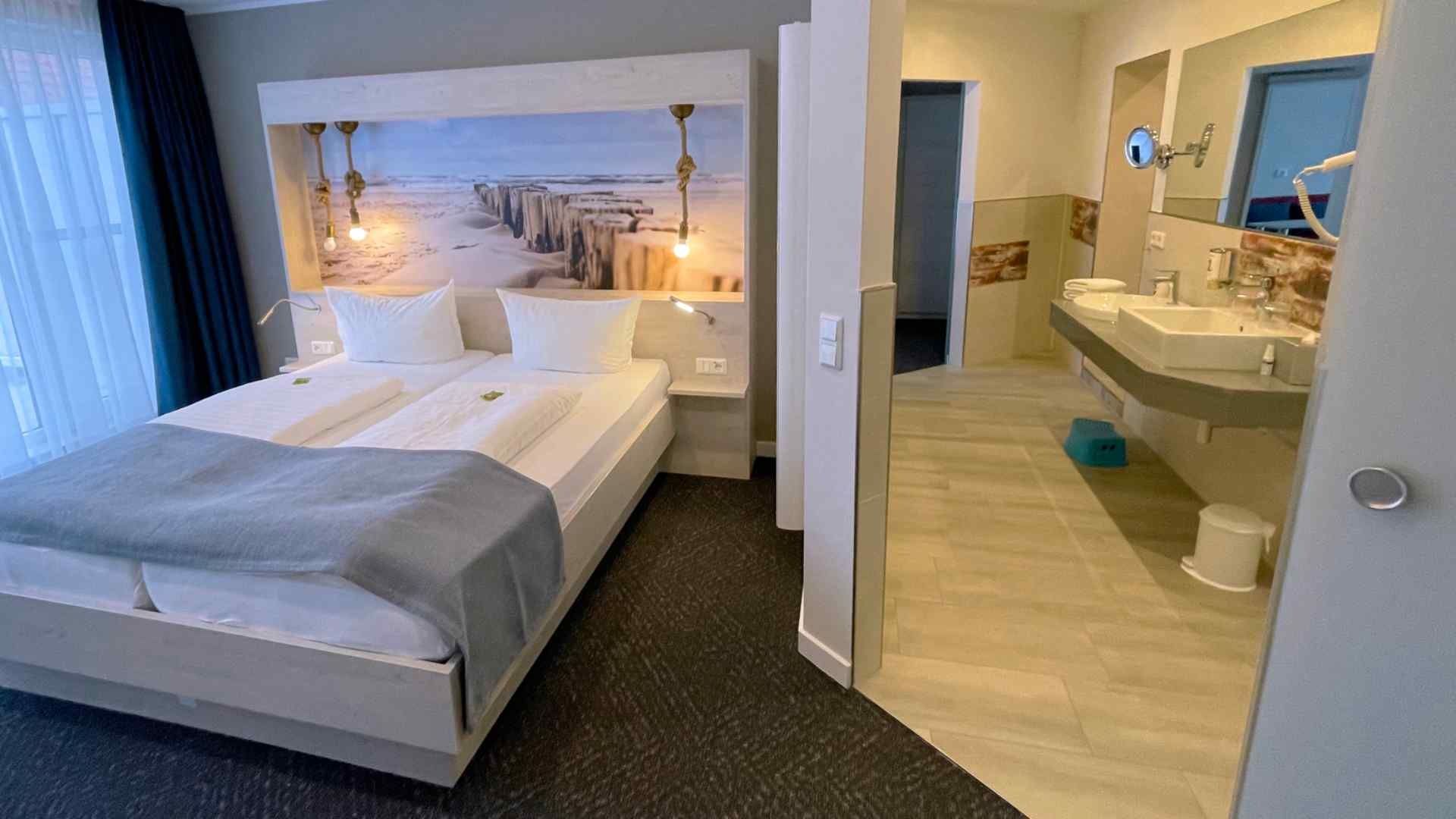 Blick auf das Doppelbett und das Durchgangsbad mit Doppelwaschbecken