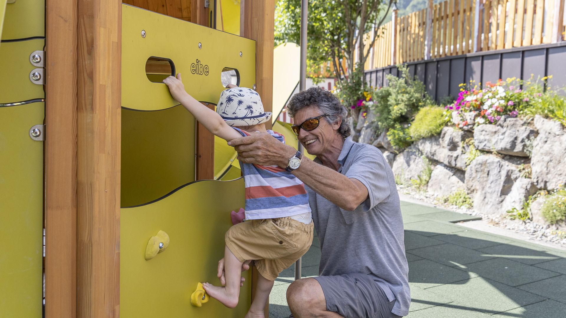 Opa spiel mit Enkel am Spielplatz