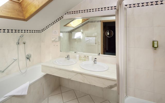 Spacious bathroom with shower, bathtub and extra WC.