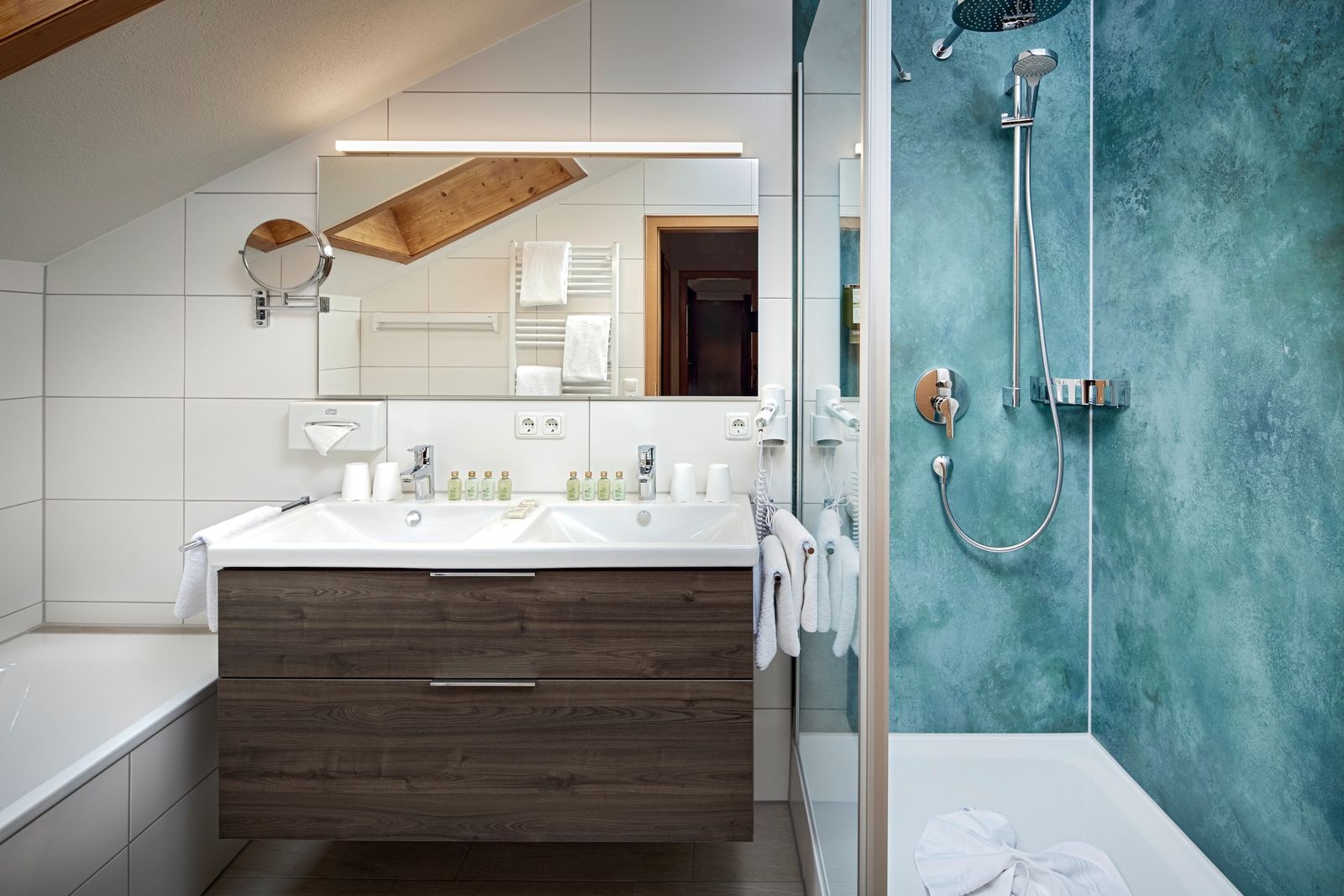 Roomy bathroom with bathtub, shower and toilet in an extra room.