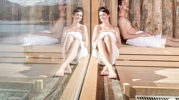 Frau sitzt in der Sauna im Spabereich des Eibsee Hotel