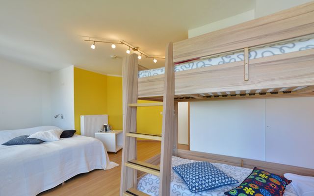 Schlafzimmer mit Doppelbett und Doppelstockbett