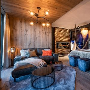 Die moderne und luxuriöse Golden-Sky-Suite mit kuscheligem Bett, liebevollen Details und großem Sofa zum entspannen.