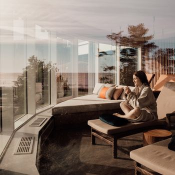 Maritimes Hotelzimmer mit Doppelbett, das zu einem Wellness Kurzurlaub an der Ostsee einlädt, rechts versperrt eine Wand die Sicht