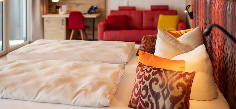 Zimmeransicht Liebesglück mit Bett, Sofa, Schreibtisch in rot gehalten