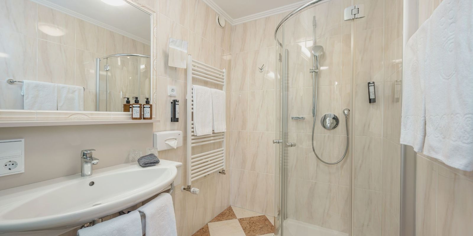 Modernes Badezimmer im Hotel die HOCHKÖNIGIN in Maria Alm mit Dusche, stilvollen Details und hochwertigen Pflegeprodukten.