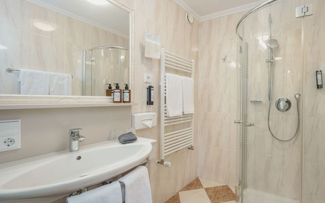 Modernes Badezimmer im Hotel die HOCHKÖNIGIN in Maria Alm mit Dusche, stilvollen Details und hochwertigen Pflegeprodukten.