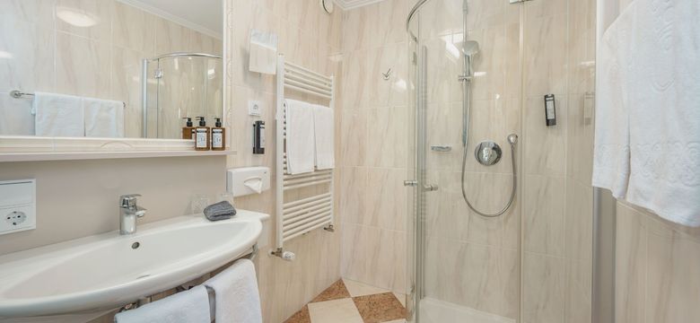 Modernes Badezimmer im Hotel die HOCHKÖNIGIN in Maria Alm mit Dusche, stilvollen Details und hochwertigen Pflegeprodukten.