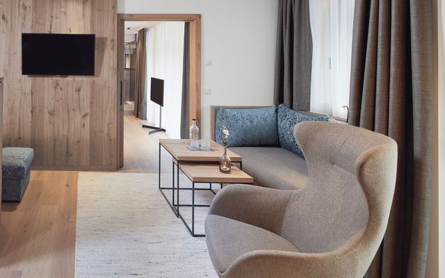 Helles Holz, elegante Stoffe und ein Hauch alpiner Eleganz: Der Wohnraum in der Suite der HOCHKÖNIGIN verbindet modernes Design mit behaglicher Wärme.Ein Ort zum Ankommen, Entspannen und Wohlfühlen in Maria Alm.