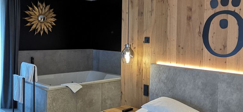 The suite with whirlpool at the HOCHKÖNIGIN Hotel in Maria Alm combines refined design, warm wood details and peaceful wellness luxury. Perfect for couples seeking style and relaxation in the Austrian Alps.