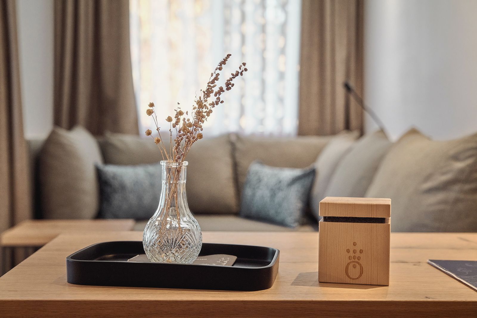Zimmer im Hotel die HOCHKÖNIGIN mit Blick auf das Sofa und den Tisch mit Dekoration im Vordergrund