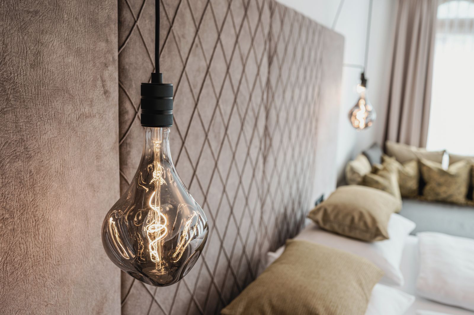 Zimmer im Hotel die HOCHKÖNIGIN mit Blick auf das Bett und Hängelampen