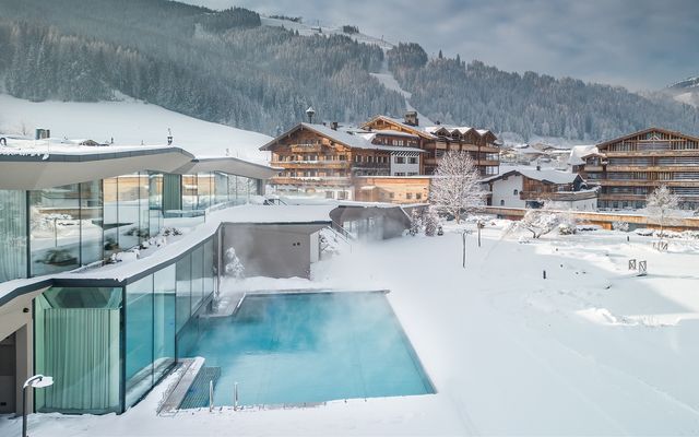 Heaven Spa Infinity Pool innen mit Glasfront zur Bergkulisse