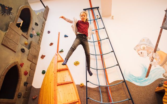 Kind springt von Ritterburg im Kinderclub